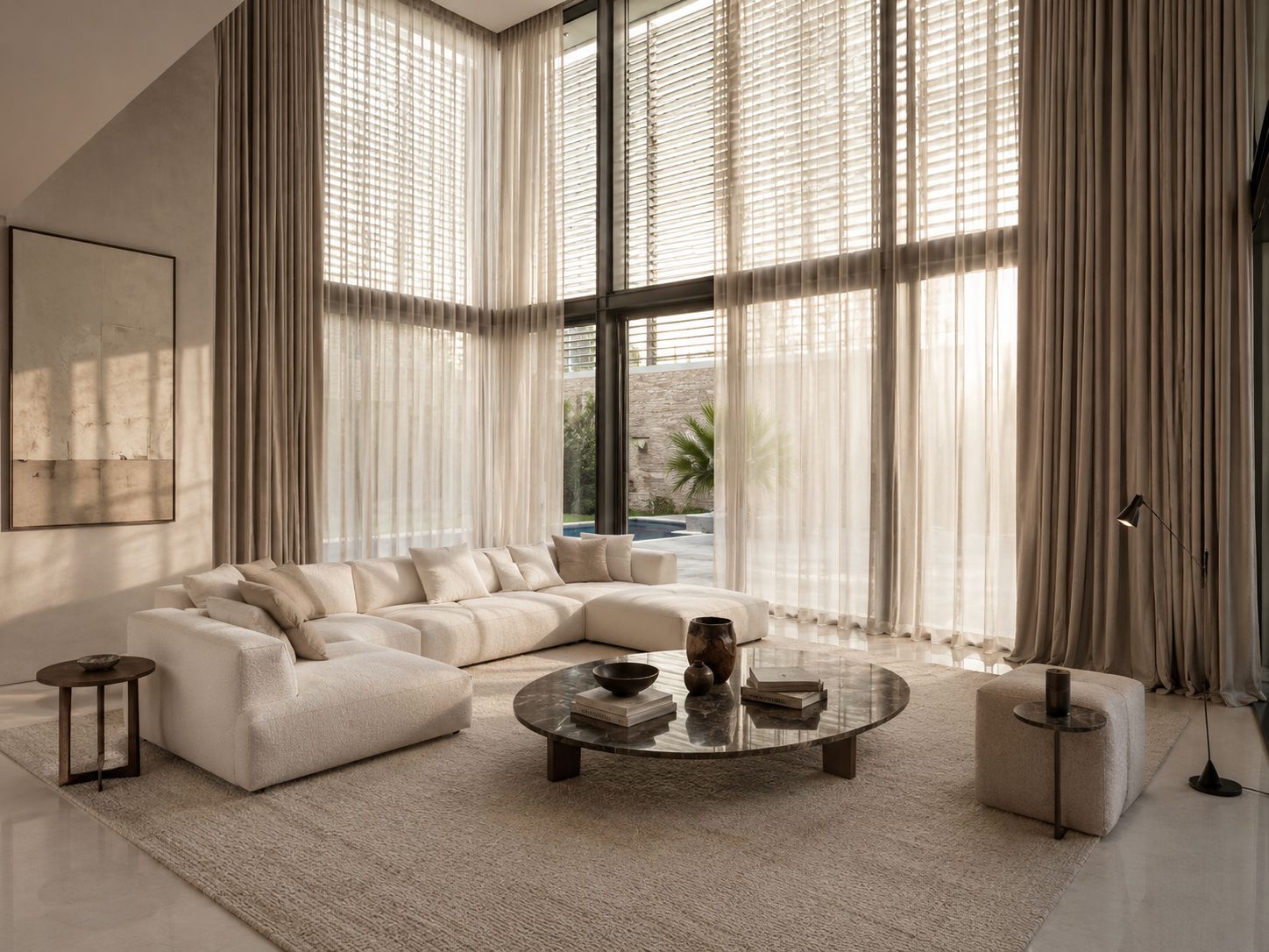 Double-height living room with sheer curtains, a cream sofa and a round marble table